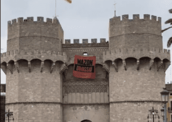 Joves de Compromís desplegan una pancarta en las Torres de Serranos contra Mazón