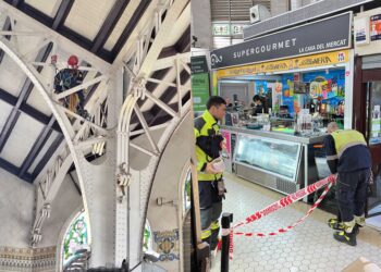 Los bomberos acordonan un pasillo del Mercado Central ante la caída de cascotes del techo