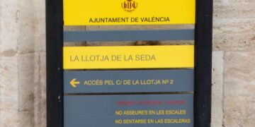 Despegan la señalética de prohibido sentarse en los escalones de la Lonja de la seda