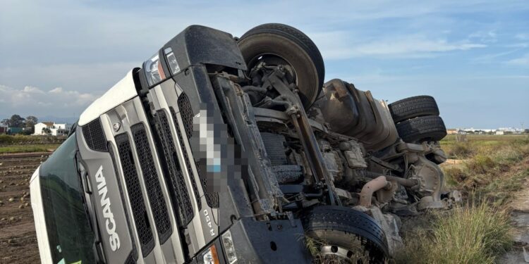 Un camión vuelca sobre un campo en el vial de servicio de la V21 en Alboraya 1 Un camión vuelca sobre un campo en el vial de servicio de la V21 en Alboraya