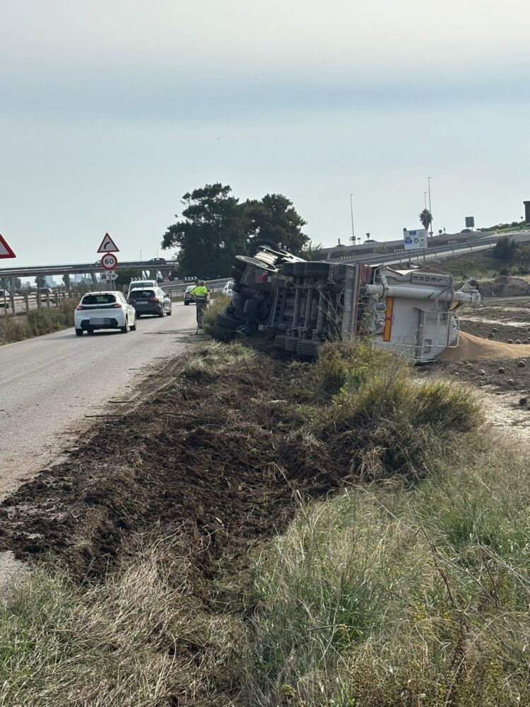 Un camión vuelca sobre un campo en el vial de servicio de la V21 en Alboraya