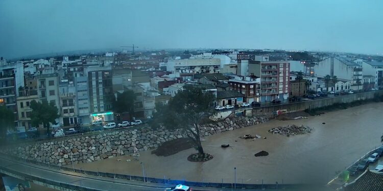 El barranco del Poyo con agua de parte a parte en Paiporta