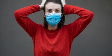 man in red sweater with face mask
