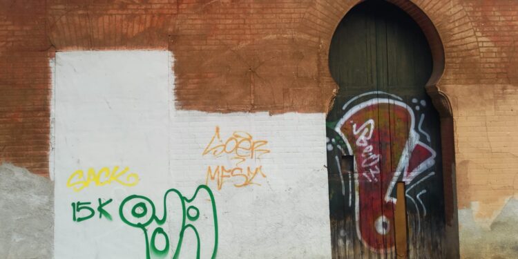 Fachada de La Ceramo en Benicalap con pintadas y carteles ilegales, Valencia.