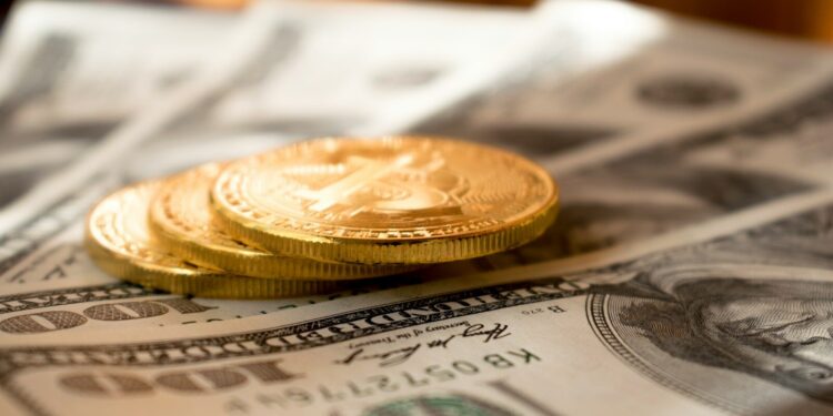 three round gold-colored coins on 100 US dollar banknotes