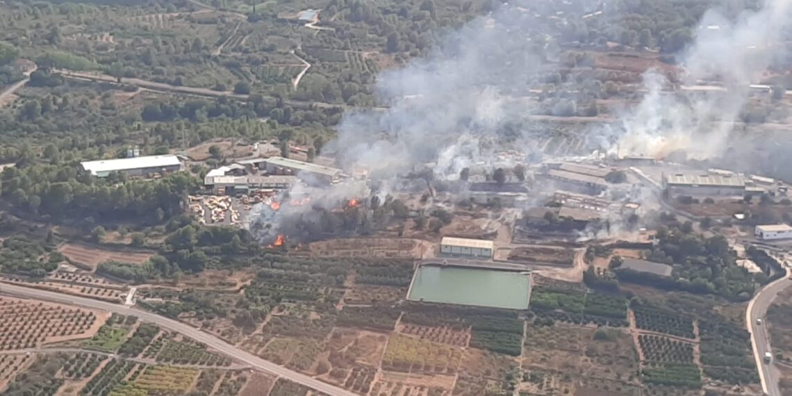 El incendio industrial en Algar de Palància obliga a cortar la luz y regular el tráfico ante la amenaza del avance forestal