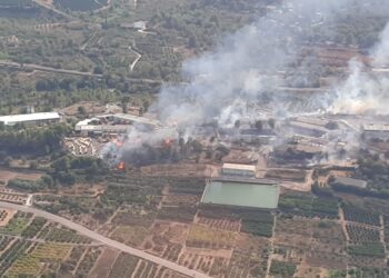 El incendio industrial en Algar de Palància obliga a cortar la luz y regular el tráfico ante la amenaza del avance forestal