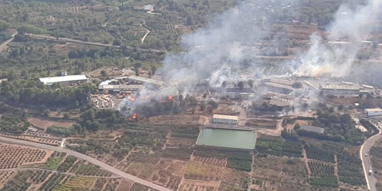 El incendio industrial en Algar de Palància obliga a cortar la luz y regular el tráfico ante la amenaza del avance forestal